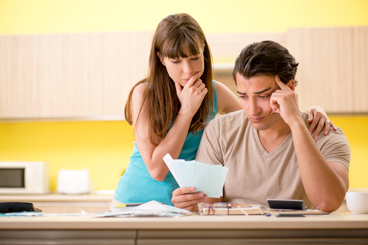 A couple at the kitchen bench going through bills and paperwork